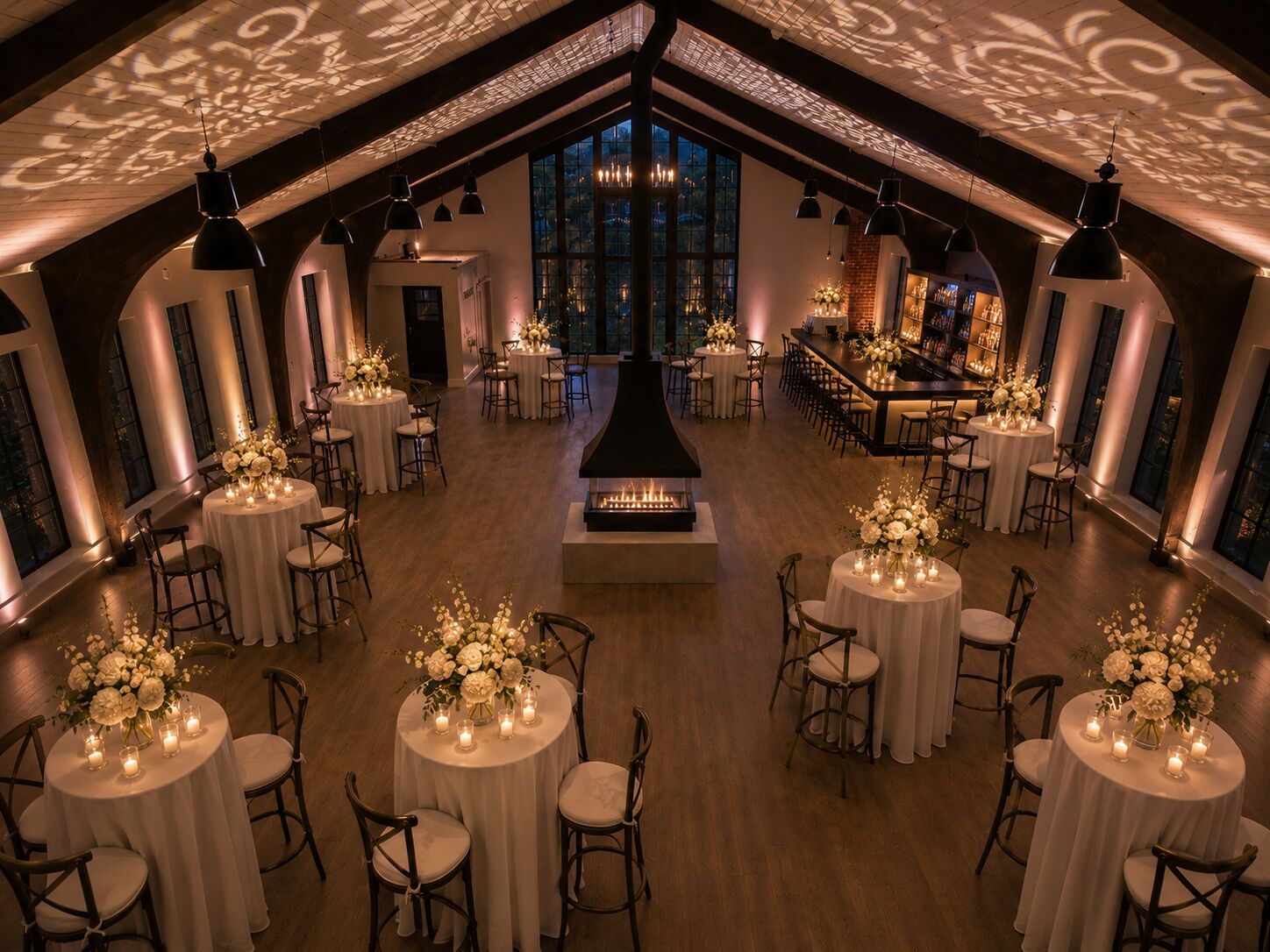 Cocktail party floor set with high-top tables, florals, and warm lighting at THE 1301